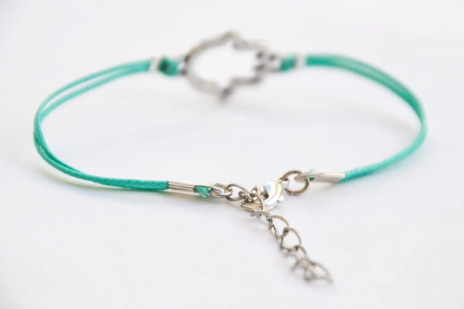 Turquoise cord bracelet with a silver Hamsa charm, evil eye protection